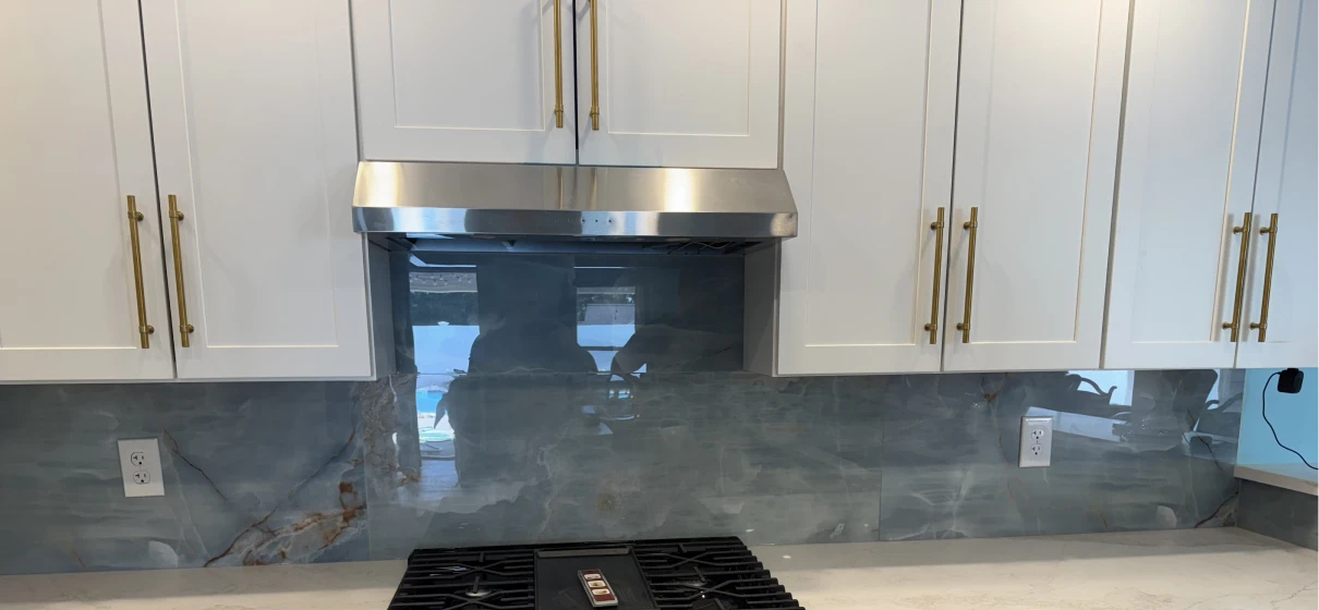 Modern kitchen with stove and white cabinets.
